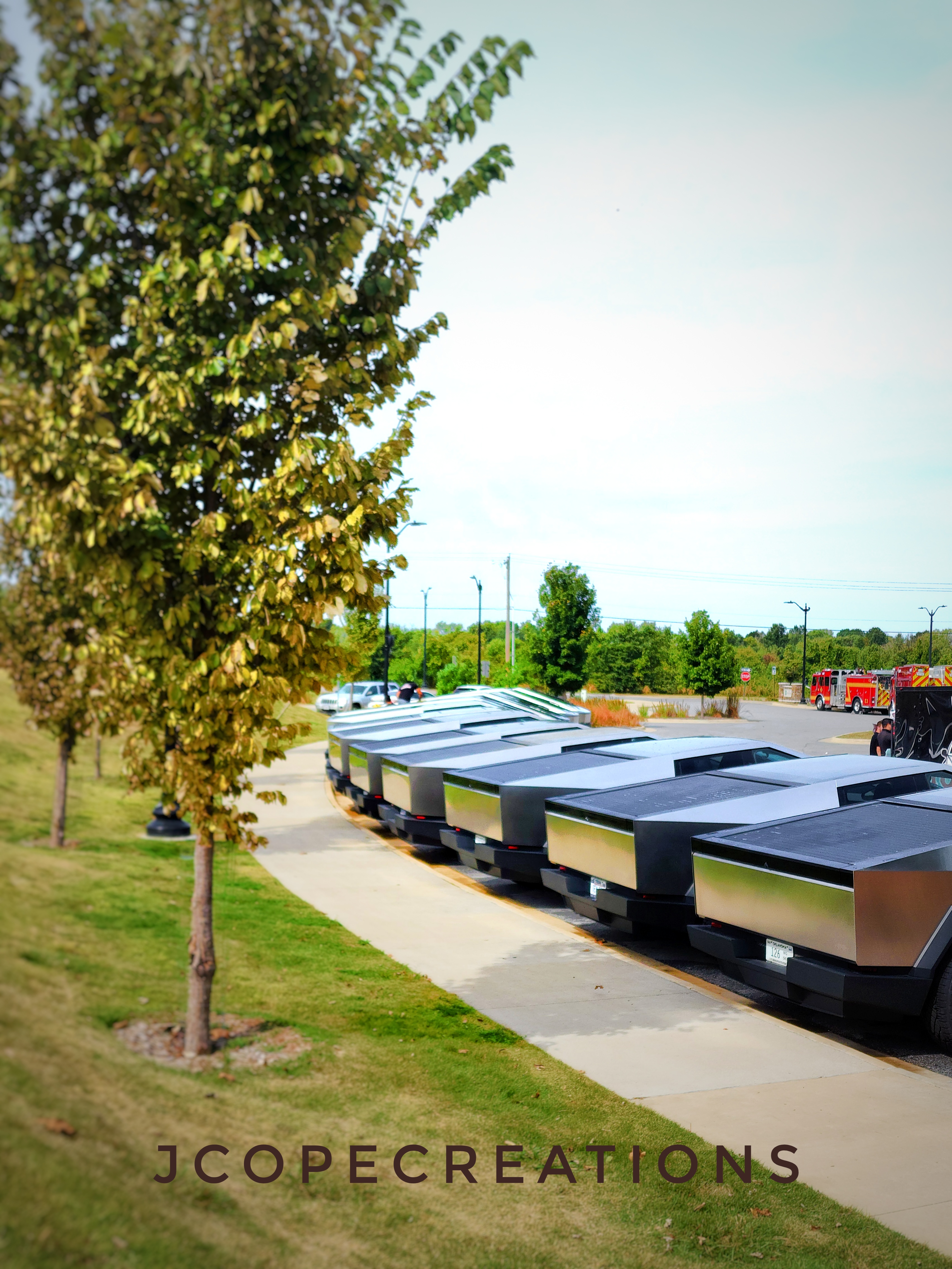 Cybertrucks lined up one after the next in a park parking lot
