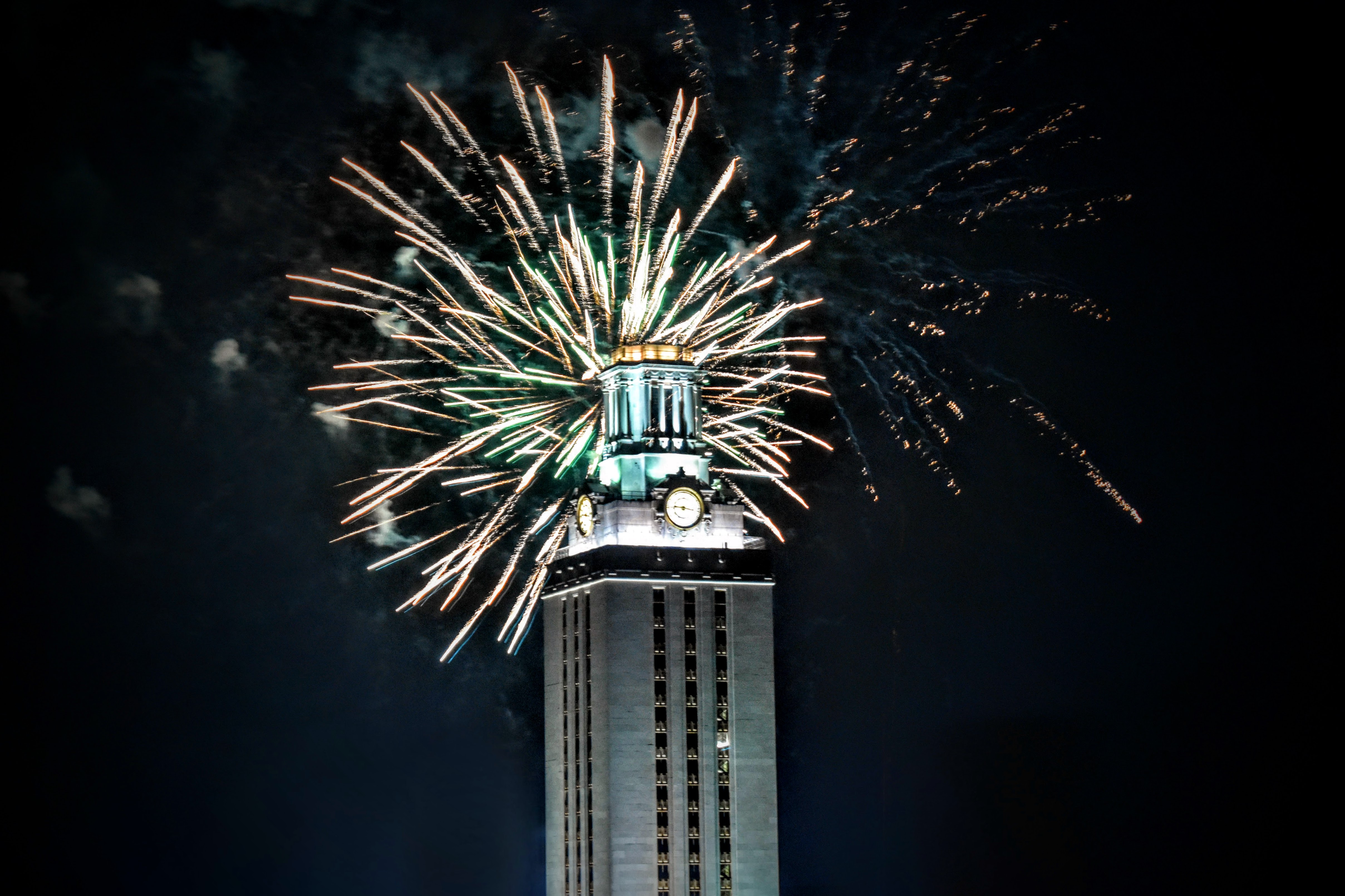 A clock tower surrounded by fireworks